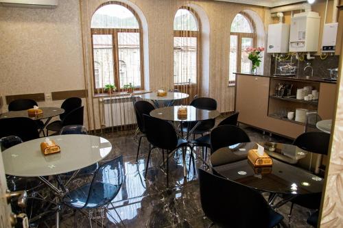 a room with tables and chairs and windows at Har-Mar Hotel in Goris