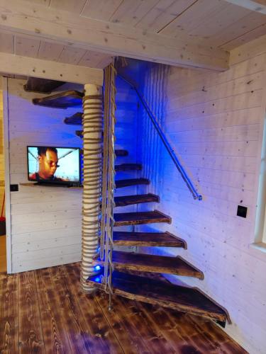 a spiral staircase in a room with a tv at Uroczy zakątek Karkonoszy in Bukowiec