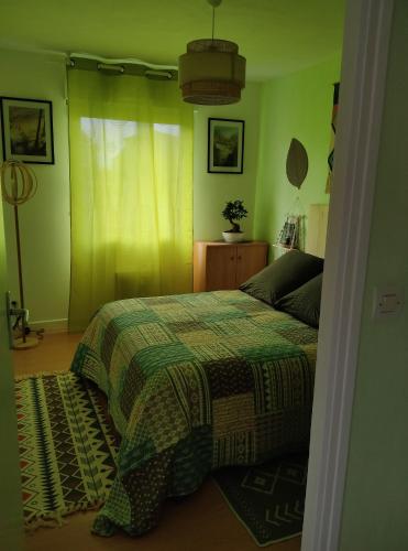 a bedroom with a bed with a green wall at TY BIHAN TAD-KOZH in Ploumagoar