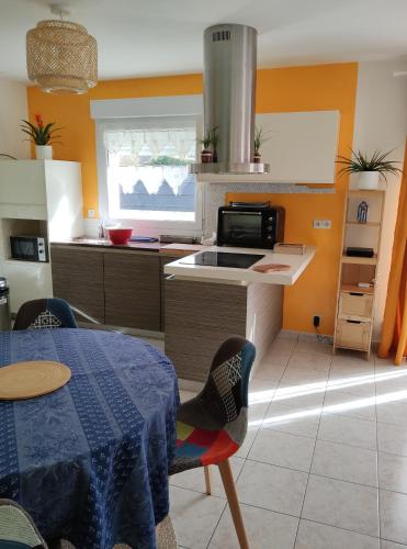 a kitchen with a table and a stove top oven at TY BIHAN TAD-KOZH in Ploumagoar