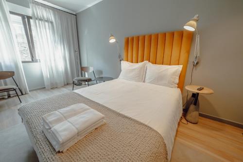 a bedroom with a large bed with a wooden headboard at River Eyes Suites in Vila Nova de Gaia