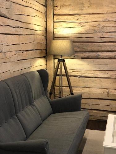 a couch in a living room with a wooden wall at Klaukse in Kolga-Aabla