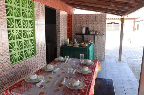 una mesa con platos y platos en una habitación en Pousada Golfinho, en Galinhos