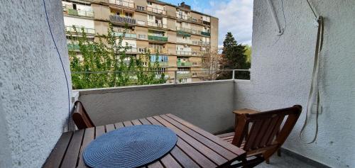 - une table et des chaises en bois sur un balcon avec un bâtiment dans l'établissement Apartment Freyja, à Split