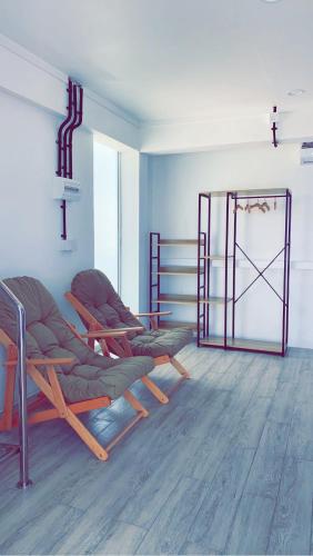 a room with two chairs and a metal gate at Hiraeth island home in Guraidhoo
