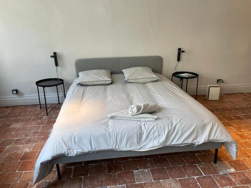 Una cama con dos mesas y dos toallas. en Laboutique, en Lormes