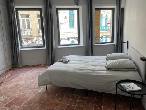 1 dormitorio con 1 cama grande y 3 ventanas en Laboutique, en Lormes
