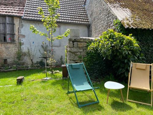 duas cadeiras e uma cadeira num quintal em Laboutique em Lormes