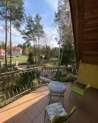 a patio with a table and chairs and a fence at Leśny Czar in Serock