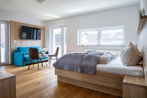 a bedroom with a large bed and a blue couch at Luxury Apartment Monte Carlo in Pörtschach am Wörthersee