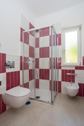 a bathroom with a shower and a toilet and a sink at Villa Maìki in Torca
