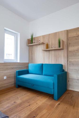 a blue couch sitting in a living room at Luxury Apartment Monte Carlo in Pörtschach am Wörthersee