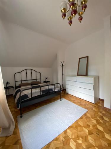 a bedroom with a bed and a dresser and a chandelier at Leśny Czar in Serock