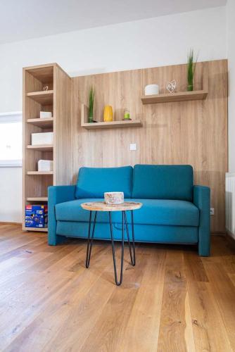 a blue couch in a living room with a table at Luxury Apartment Monte Carlo in Pörtschach am Wörthersee