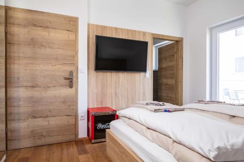 a room with three beds and a television on a wall at Luxury Apartment Monte Carlo in Pörtschach am Wörthersee
