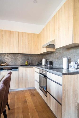 a kitchen with wooden cabinets and stainless steel appliances at Luxury Apartment Monte Carlo in Pörtschach am Wörthersee