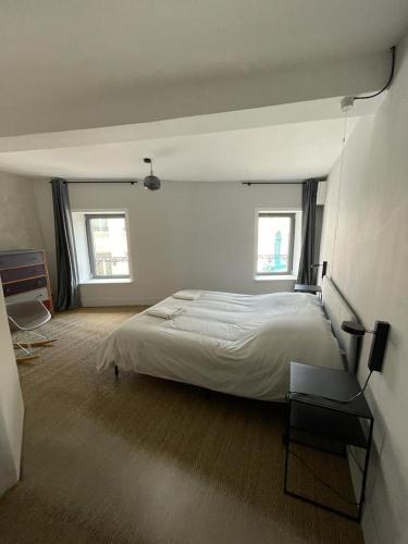 1 dormitorio con 1 cama grande y 2 ventanas en Laboutique2, en Lormes