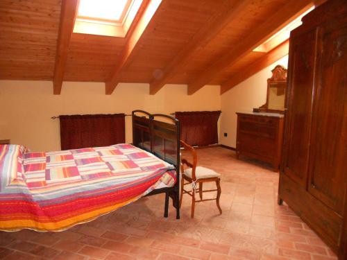 a bedroom with a bed and a chair in a room at Agriturismo Monrabbioso in Cereseto