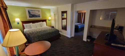 a hotel room with a bed and a television at Redondo Inn and Suites in Redondo Beach