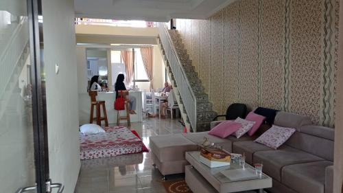 ein Wohnzimmer mit einem Sofa und einem Tisch in der Unterkunft Homestay Bilqis Full House 4 Kamar 5 Bed Syariah in Wonosobo