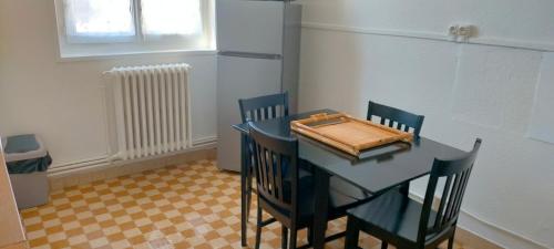een keuken met een tafel en stoelen en een koelkast bij Chez J&F in Elbeuf