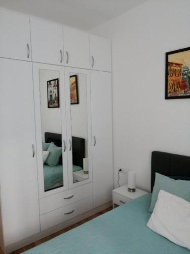 a bedroom with a bed and a dresser with mirrors at Center Sunrise Apartment in Novi Sad