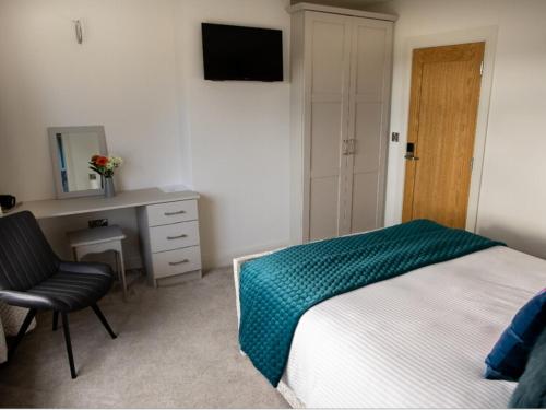 a bedroom with a bed and a desk and a television at Ashwoods House in Enniskillen