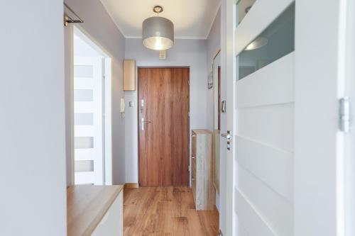 einen Flur mit Holztür in einem Haus in der Unterkunft AP Apartments Kołobrzeska in Danzig