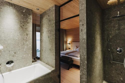 ein Bad mit einer Dusche und ein Schlafzimmer mit einem Bett in der Unterkunft Peterhof Chalets in Batschuns