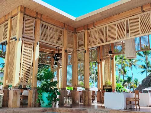 a restaurant with tables and chairs and palm trees at Fiesta Americana Puerto Vallarta All Inclusive & Spa in Puerto Vallarta