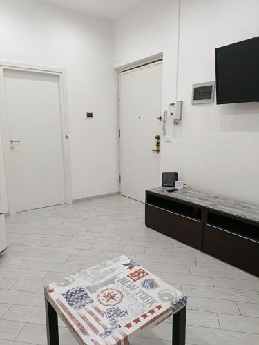 a kitchen with a table in a room with white walls at Il filo di Jordi in Savona