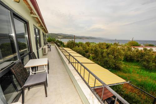 balcón con sillas, mesa y vistas al agua en Assos No9 Hotel, en Canakkale