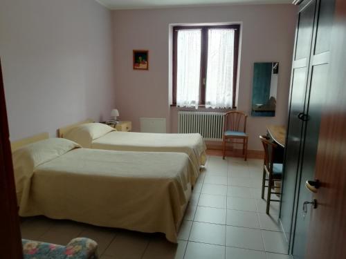 a hotel room with two beds and a window at Albergo Breglia in Plesio