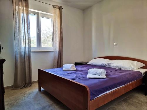 a bedroom with a bed with two towels on it at BELLEVUE - Old Navalis in Stara Novalja