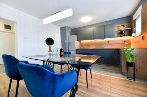 cocina y comedor con mesa y sillas azules en Deluxe Apartment Soline en Zadar