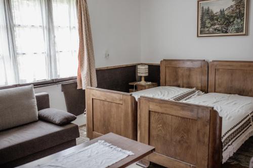 1 dormitorio con cama de madera y sofá en Ildikó Vendégház, en Magyarszombatfa