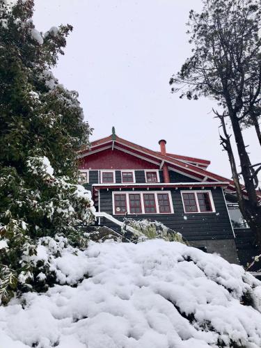 a house with a pile of snow in front of it at La Miralejos in San Carlos de Bariloche