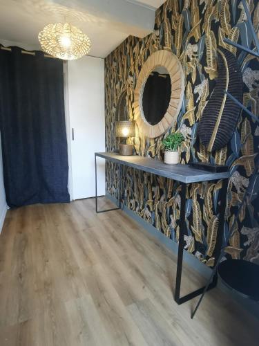 a room with a table and a mirror on a wall at La Canopée in Cholet