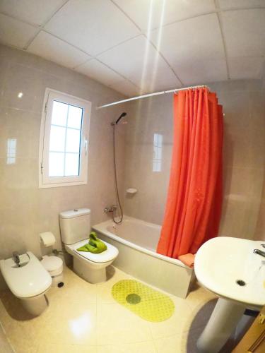 a bathroom with a toilet and a sink and a shower at Apartamento junto la playa in Gran Tarajal