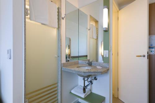 a bathroom with a sink and a mirror at ibis budget Porto Alegre in Porto Alegre