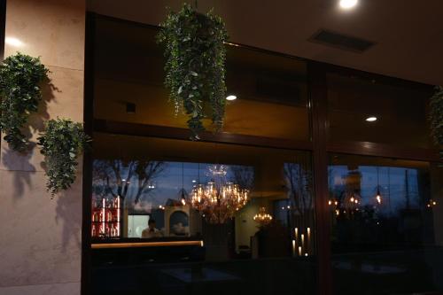 a window of a restaurant with a chandelier at Hotel Xemar in Arad