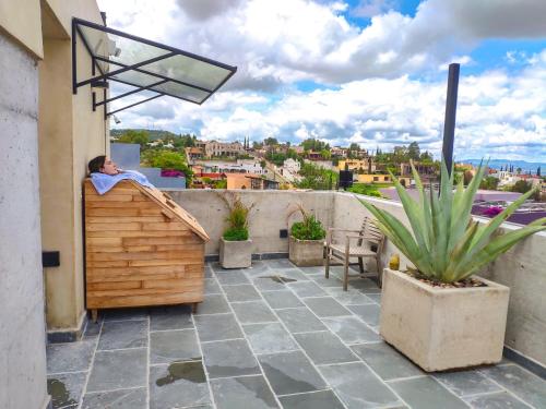 a person sleeping on a balcony with a view of a city at Cuna del Cielo in San Miguel de Allende