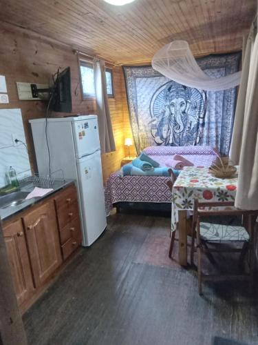 a kitchen with a refrigerator and a table in a room at Recuerdos in Atlántida