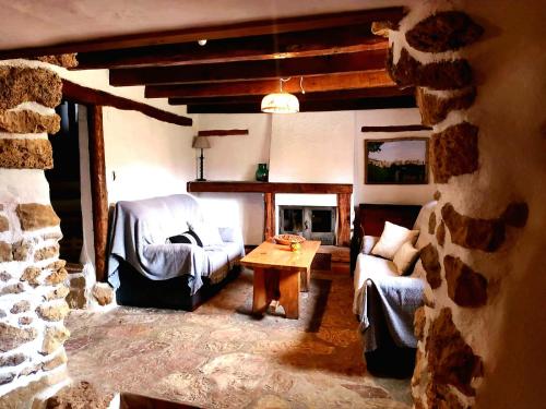 sala de estar con chimenea de piedra y mesa en Casa los chaparrales, en Los Anchos