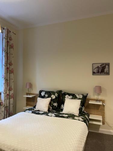 a bedroom with a bed with white sheets and pillows at Apartament Bankowy in Olecko