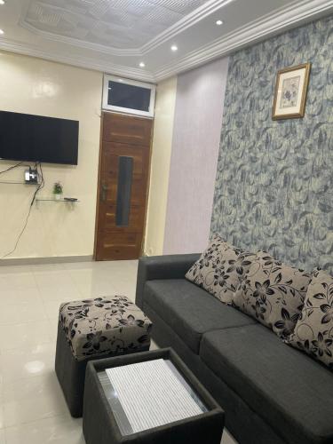 RESIDENCE MERCURE في داكار: غرفة معيشة مع أريكة وتلفزيون