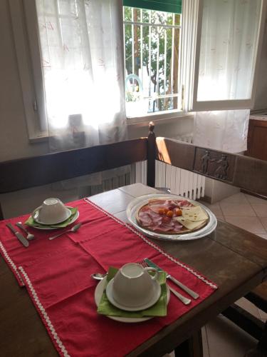 a table with a plate of food on a red table cloth at Da Scilla in Punta Marina