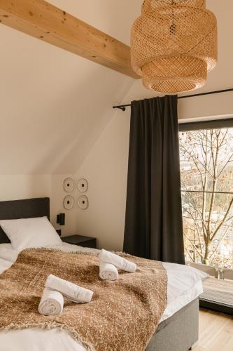 a bedroom with a bed with towels on it at Osada Matygówka in Gliczarów