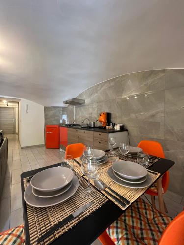 Casa Foria Holiday Home Naples في نابولي: غرفة طعام مع طاولة مع الأطباق وكؤوس النبيذ