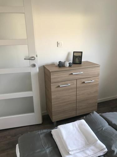 a bedroom with a wooden dresser and a bed at Pogánykő Vendégház 2 in Pákozd